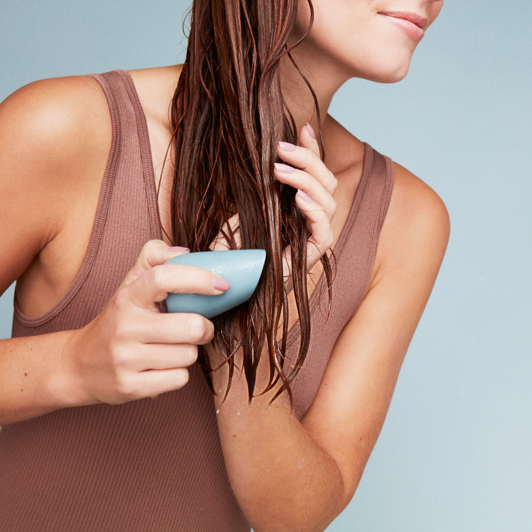 Woman rubbing a moisturize conditioner bar in her hair