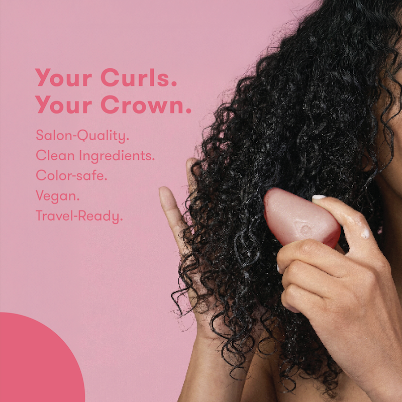 Picture of a woman with holding HiBAR conditioner bar against her hair with text that reads: Your Curls. Your Crown. Salon Quality. Clean, Vegan Formula. Color-safe. Travel-Ready.