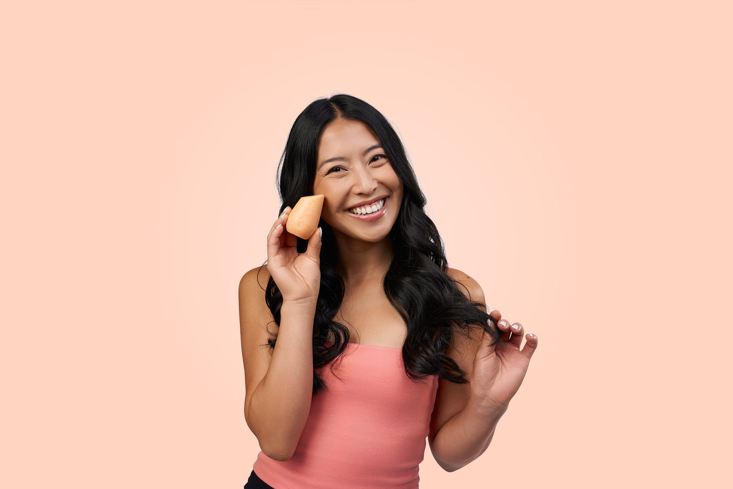 Model with dark wavy hair holding a beige Hibar shampoo bar on a beige background.