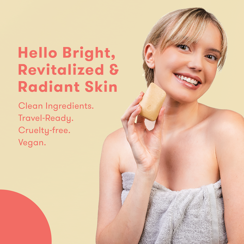 Woman holding face wash bar with text about skincare products on a light beige background. Hello bright, revitalized & radiant skin. Clean ingredients. Travel-ready. Cruelty-free. Vegan.